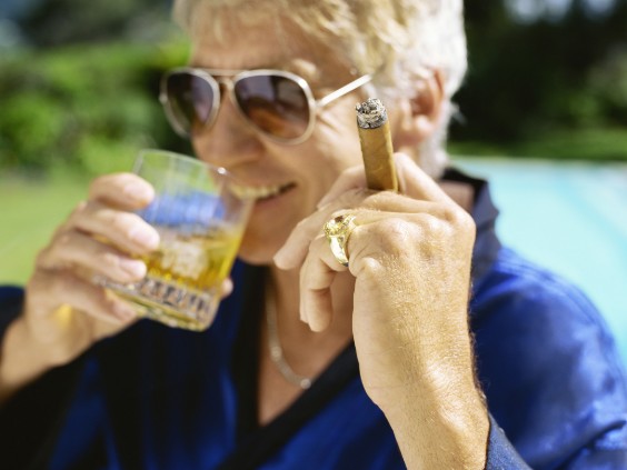 Mann raucht und trinkt Whisky